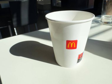 McDonald 'ın fincanı modern restoran içlerindeki güneş ışığı masasında..