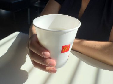 Sunlit Restoran 'da McDonald' ın bardağını tutan kadın..