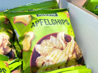 Karton kutuda sergilenen yeşil ambalajlı çıtır elma cipsleri.