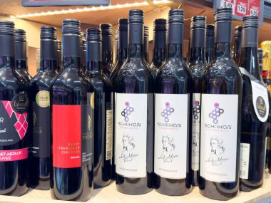 Rafta çeşitli şarap şişeleri sergileniyor..