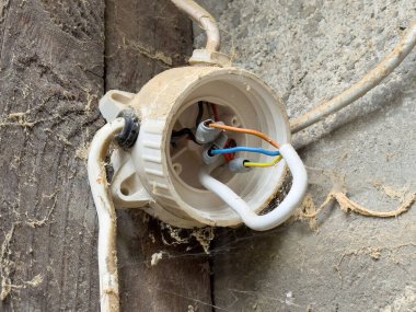 Tozlu ortamda açık renk kodlu kablolarla elektrik bağlantı kutusunu aç.