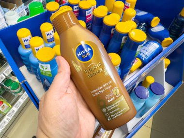 Elinde Nivea güneşi tropikal bronz şişeyi vitrine koydu..