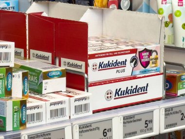 Kukident ve korega takma dişleri kutulara yapıştırılmış süpermarket rafı..