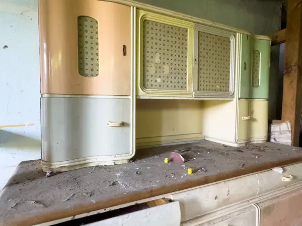 Terk edilmiş panelleri olan eski mutfak dolabı..