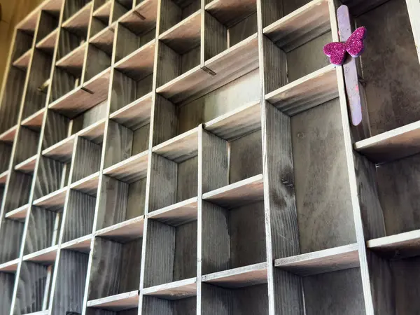 Tek bir dekoratif pembe kelebek sopasıyla boş ahşap ızgara..