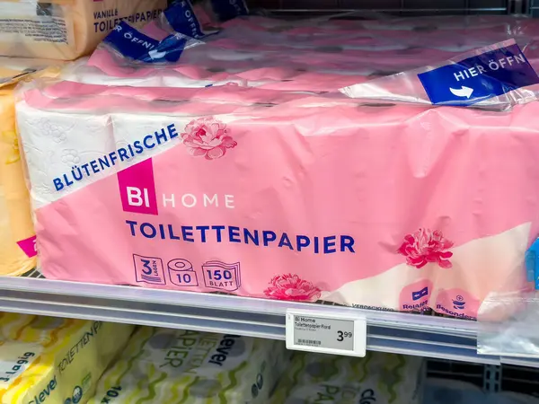 Süpermarket rafında pembe çiçekli tuvalet kağıdı ambalajı.