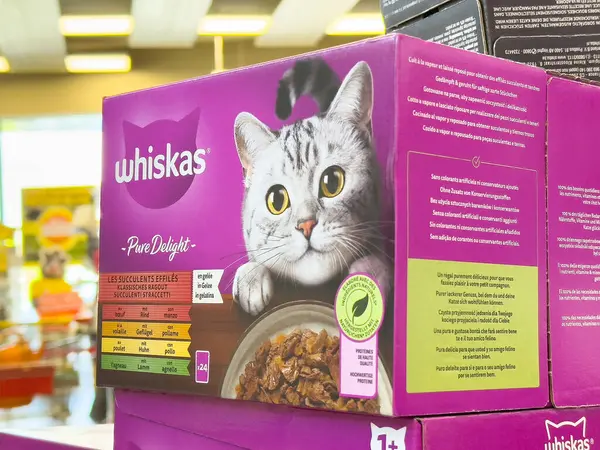 Mağaza koridorunda gri tekir kedi resmi olan Whiskas kedi maması paketi.