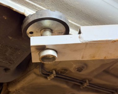 Otomotiv kriko takımının araç şasisi üzerindeki yakın çekimi.