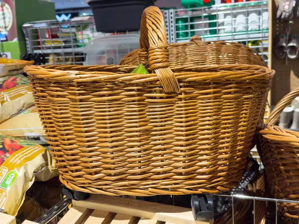 Depoda tekerlekleri olan hasır alışveriş sepeti.