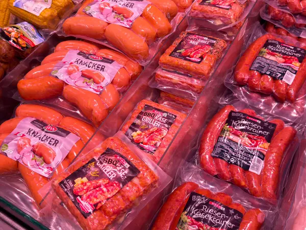 Süpermarket vitrininde çeşitli paketlenmiş sosisler.