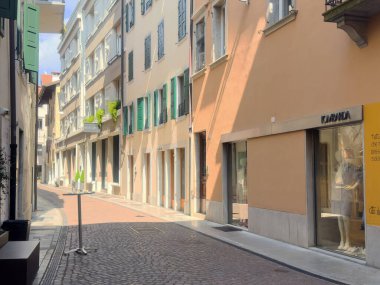 Butik dükkanları ve güneşli cepheleri olan sessiz Avrupa caddesi.