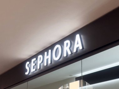 Siyah arkaplanda beyaz harflerle aydınlatılmış Sephora mağaza önü tabelası.