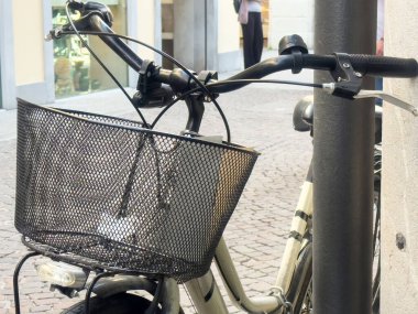 Şehir sokağına park etmiş metal sepetli bisiklet..