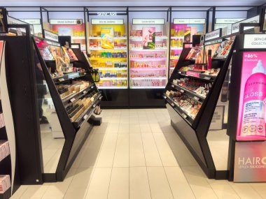 Renkli cilt bakımı ve makyaj malzemeleriyle dolu canlı kozmetik mağazası koridoru.