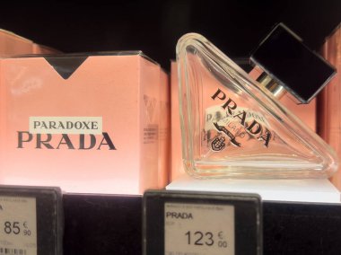 Benzersiz şişe tasarımı ve fiyat etiketleriyle Prada paradokslu parfüm görüntüsü.