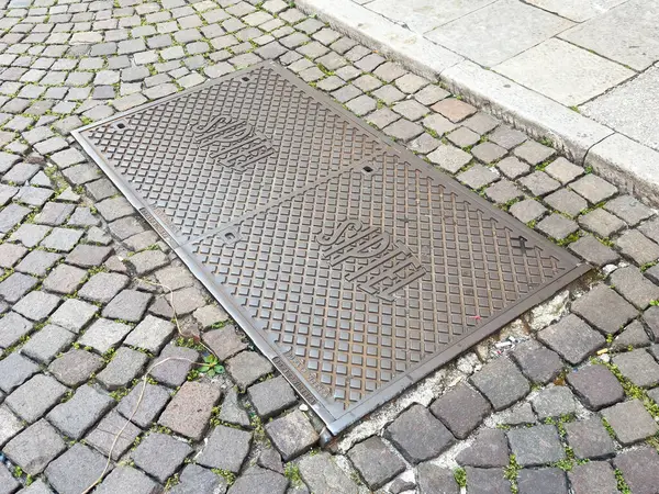 Kabartmalı metinle kaldırımda metal rögar kapağı..