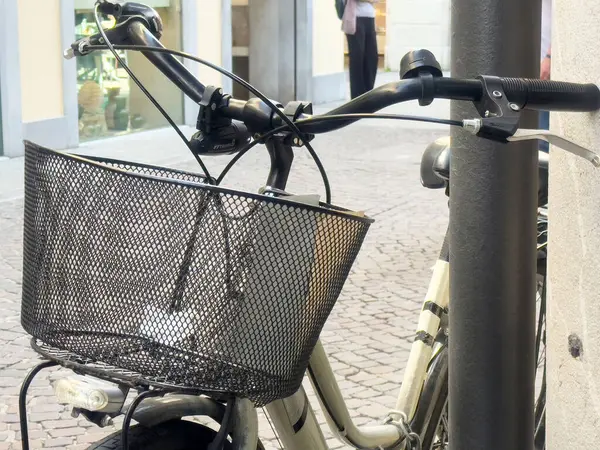 Şehir sokağına park etmiş metal sepetli bisiklet..