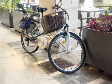 Şehir merkezinde taş kaldırıma park etmiş elektrikli bisiklet..