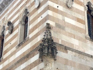 Çizgili cephe ve heykel detaylarıyla dekore edilmiş mimari.