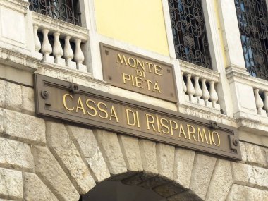 Taş kemer ve metal tabelalı tarihi İtalyan banka binası cephesi.