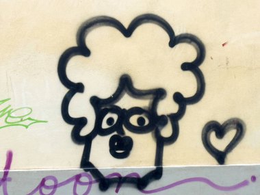 Graffiti sanatı: tuhaf çizgi film yüzü, kıvırcık saçlar ve duvarda kalp..