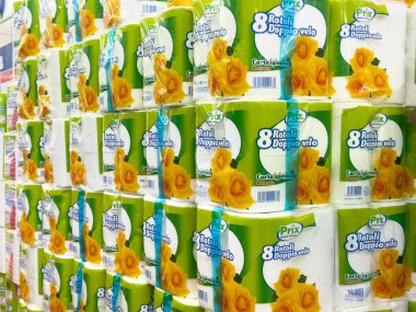 Mağaza koridorunda çiçek desenli istiflenmiş tuvalet kağıdı paketleri.