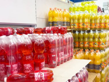 Raflardaki büyük şişelerde çeşitli aromalı meşrubat çeşitleri..