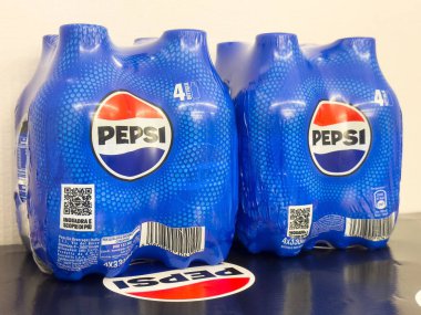 Pepsi dört paketli, ikonik kırmızı ve mavi renkli şişeler sergileniyor.