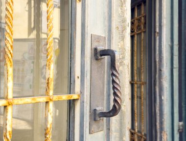 Kırsal metal kapı kolu yıpranmış ahşap kapı ve spiral tasarım..