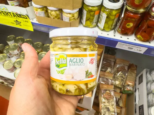 Market koridorunda çeşitli reçellerle marine edilmiş sarımsak kavanozu..