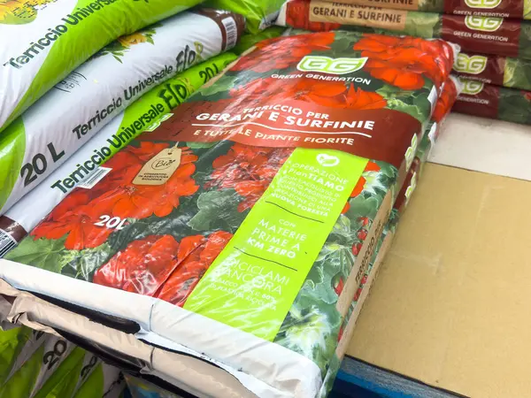 Sardunyalar için saksı toprağı ve çevre dostu etiketli surfinya çiçekleri..