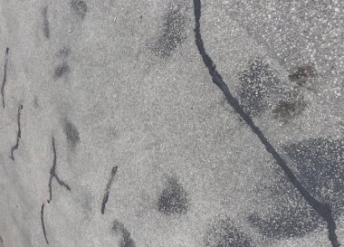 Çatlaklı asfalt dokusu ve şehir kaldırımında yüzey ayrıntıları.