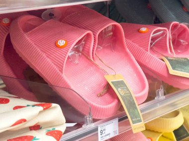 Fiyat etiketli pembe lastik terlikler mağazada.