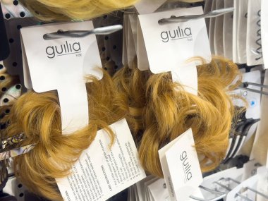 Güzellik malzemeleri dükkanında sergilenen sarı saç eklentileri.