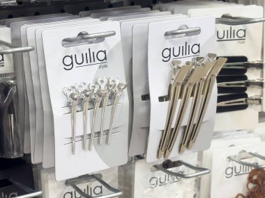 Mağazadaki raflarda çeşitli metalik saç tokaları.