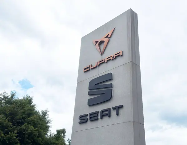 Bulutlu gökyüzüne karşı Cupra koltuk bayisi tabelası.