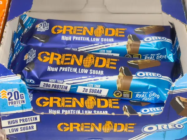 Grenade oreo protein çubukları besleyici etiketlerle birlikte kutuda gösterilir.