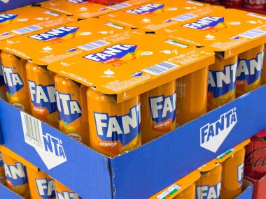 Markette mavi karton tepsilerde fanta portakallı soda kutuları..
