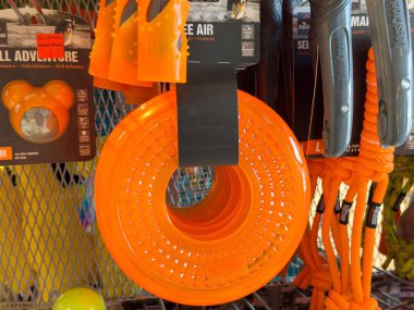 Portakal rengi köpek oyuncakları ve aksesuarlar evcil hayvan dükkanında sergileniyor. İplerle ve çiğneme oyuncaklarıyla..