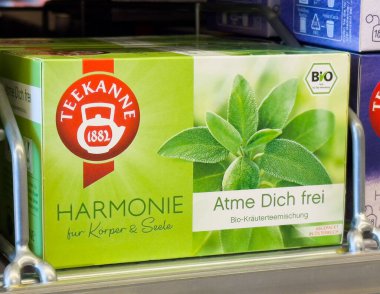 Rafta yeşil yaprak desenli Teekanne bitki çayı paketi.