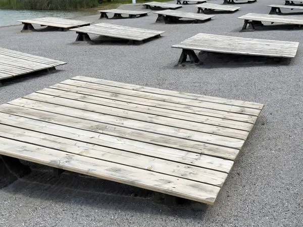 Açık alanda çakıl taşı yüzeyinde tahta paletler..