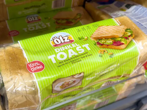 Rafta yeşil ve beyaz etiketli dinkel tost ekmeği..