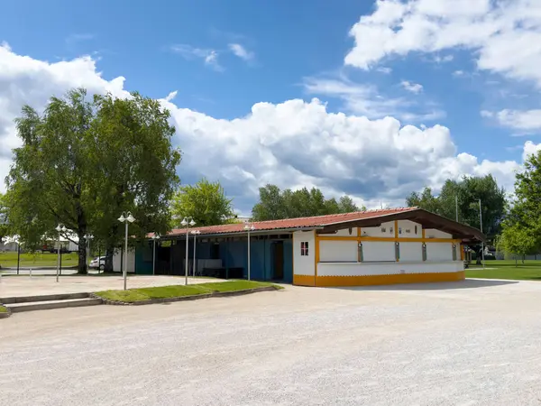 Yazın ağaçlı ve bulutlu gökyüzü olan boş park köşkü.