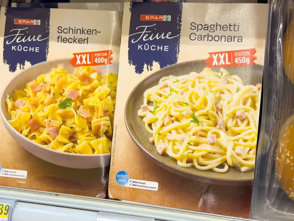 Schinkenfleckerl ve spagetti carbonara içeren paketlenmiş makarna yemekleri..