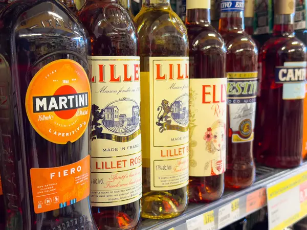 Süpermarket koridorunda çeşitli aperatif şişeleri sergileniyor.