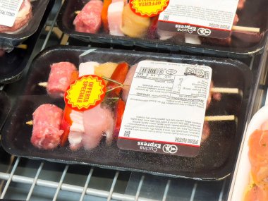 Market vitrininde özel teklif etiketli paketlenmiş et şişleri.