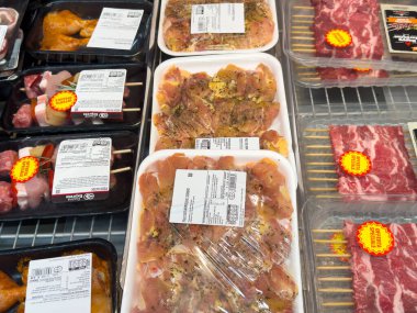 Markette paketlenmiş et sergisi: raflarda tavuk ve domuz pirzolası.