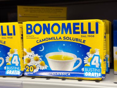 Bonomelli papatya çayı çözünebilir çay kutusu rafta papatya çiçekleri ve çay fincanı ile.