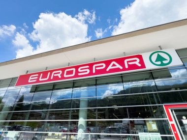 Avrupai süpermarket dış görünüşü cam pencerelerde açık mavi gökyüzü yansıması ile.