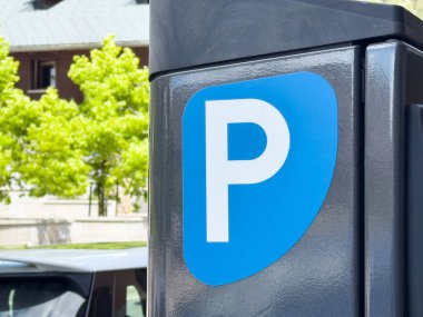 Arka planda İtalyan bayrağı olan şehir caddesinde mavi park levhası.